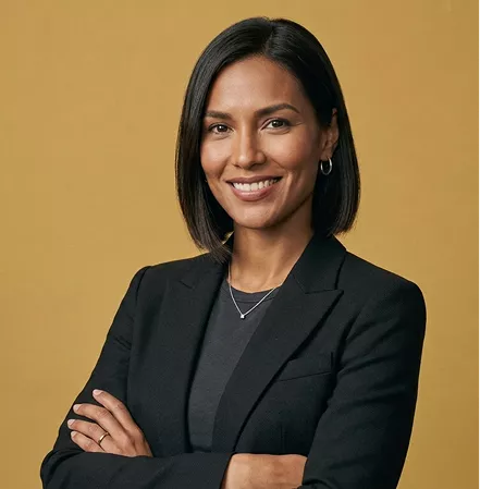 Professional headshot of a smiling woman with sleek dark bob hair, wearing a black blazer, arms crossed, on a mustard background.